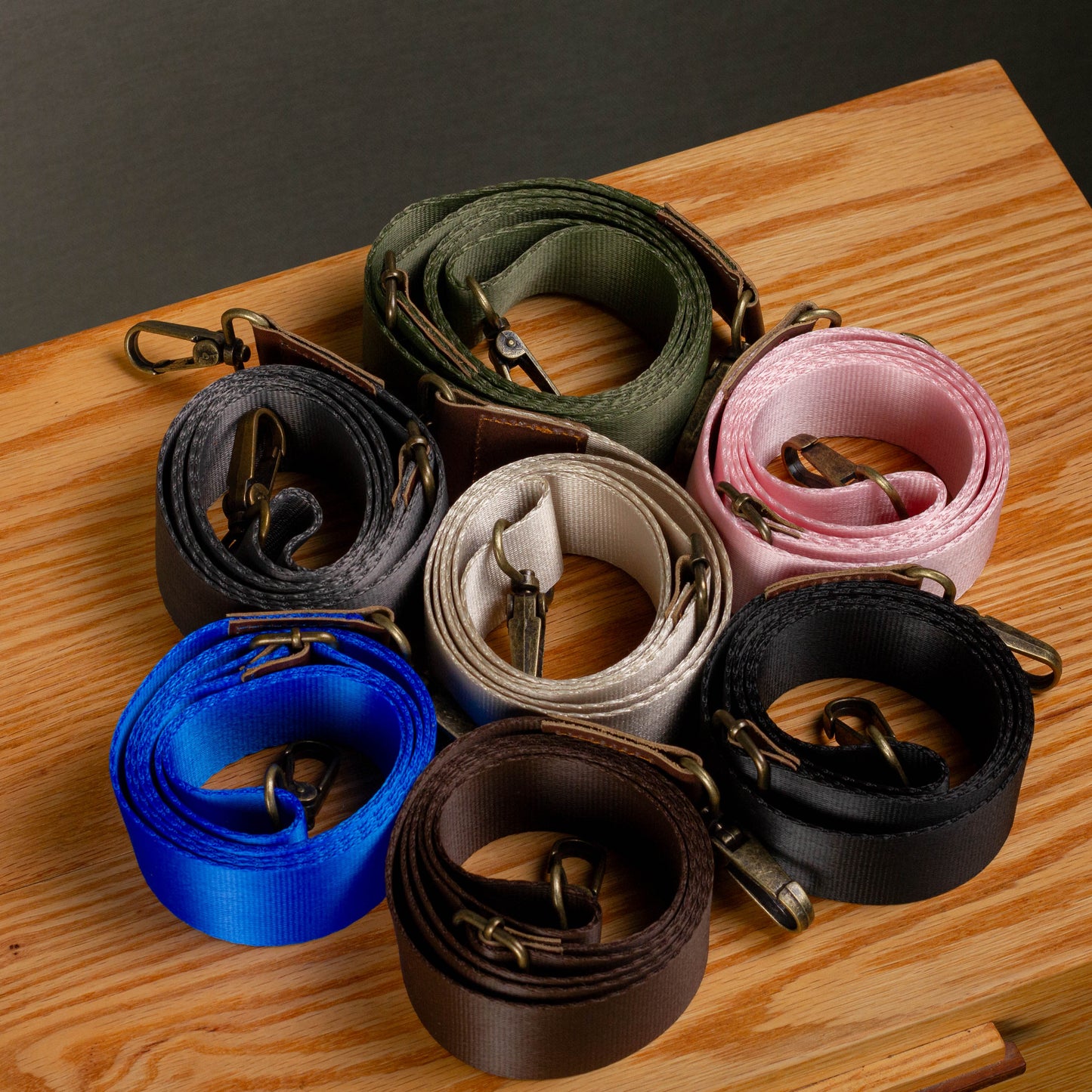 Collection of dog leashes in various colors on a wooden surface