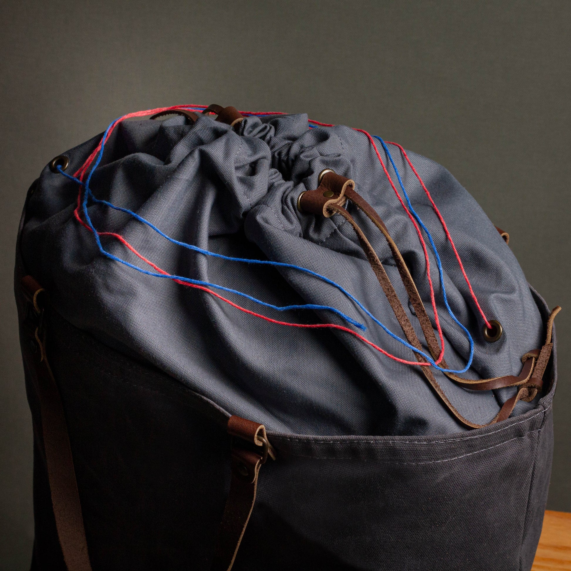 Drawstring bag with blue and red strings on a dark background