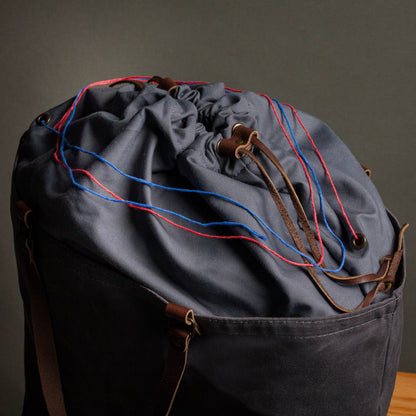 Drawstring bag with blue and red strings on a dark background