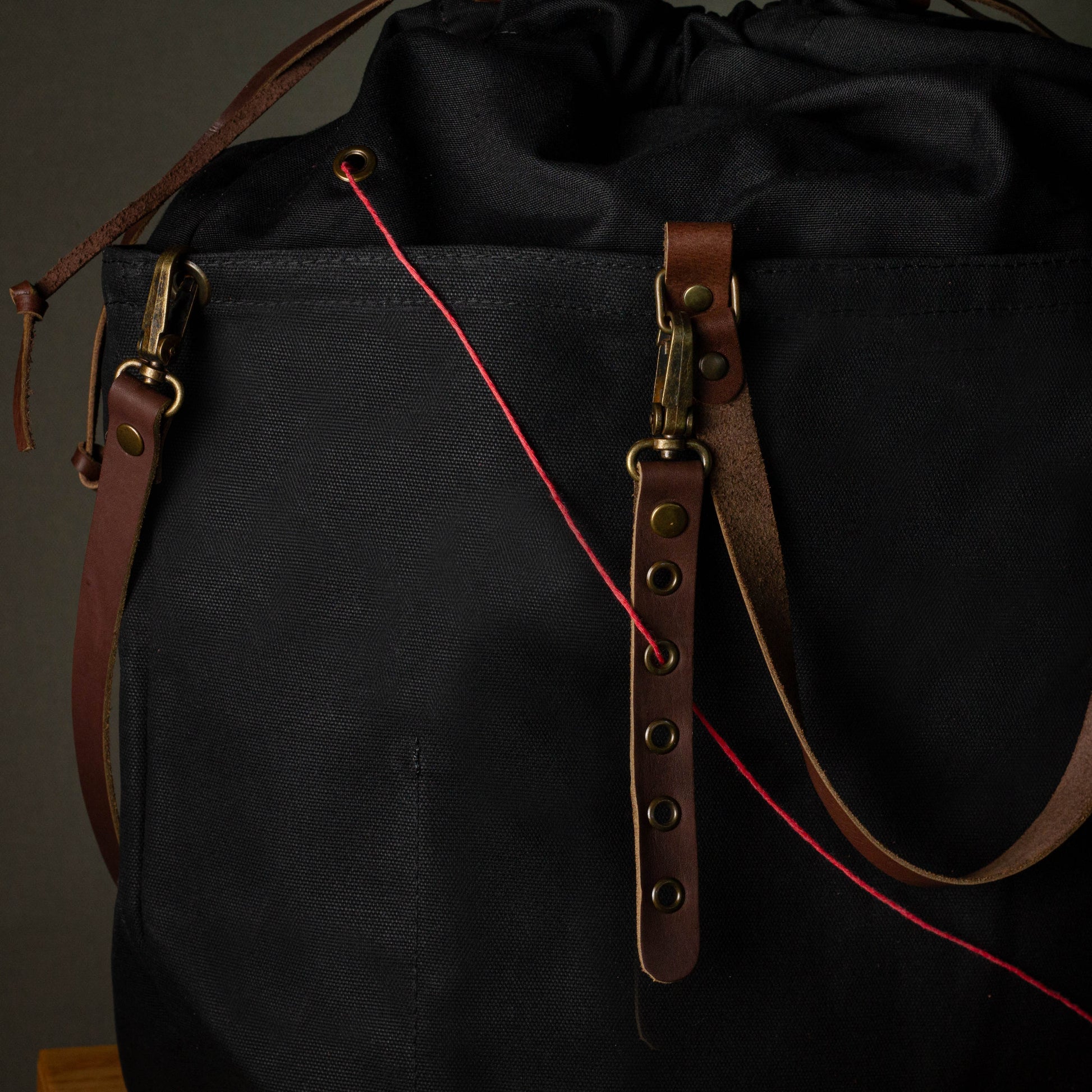 Black bag with brown leather straps on a dark background
