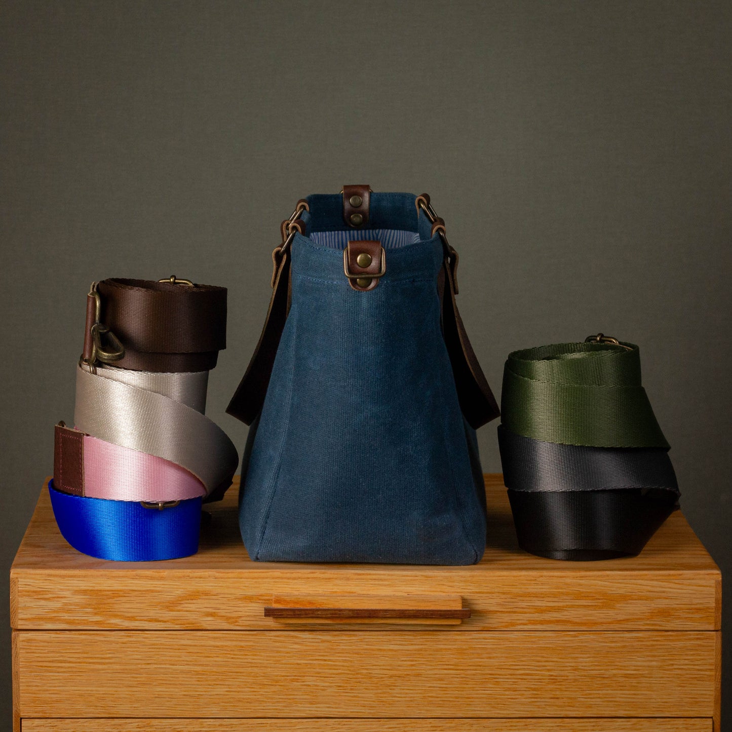 Collection of colorful bags on a wooden surface with a gray background