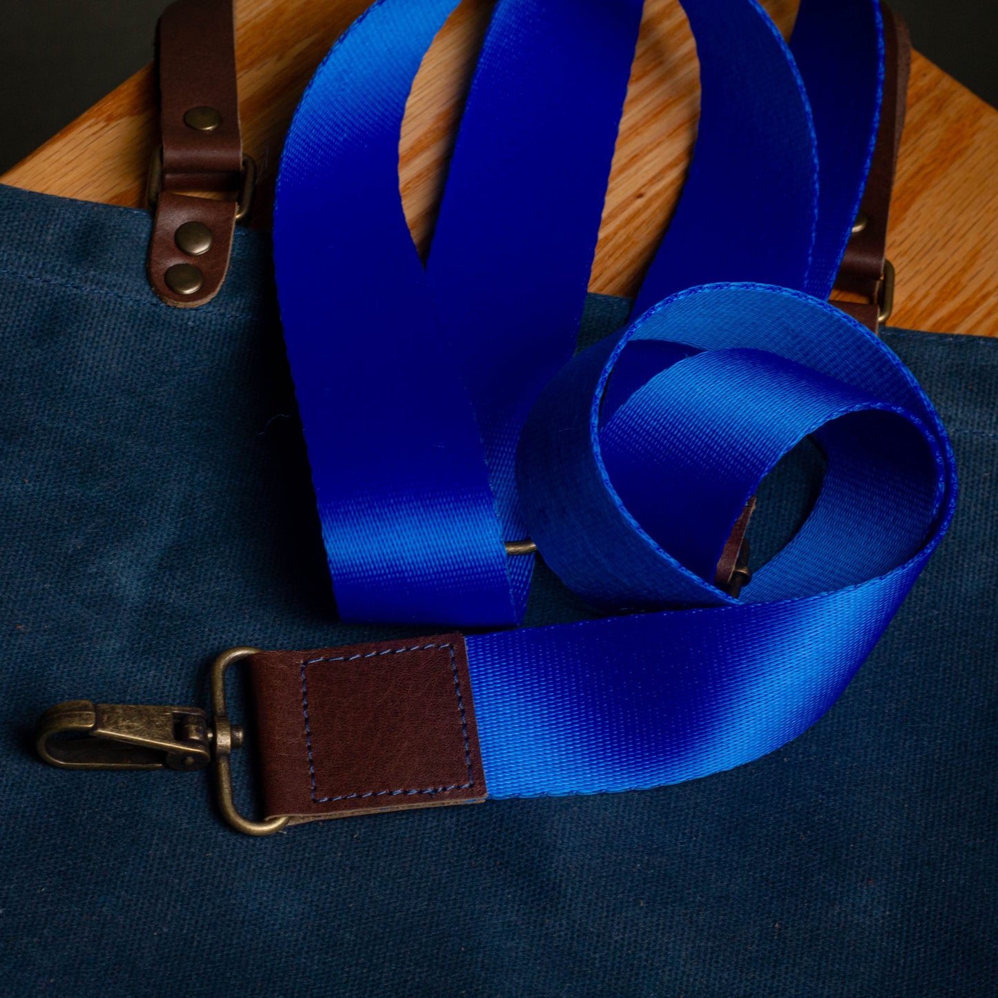 Blue suspenders with brown leather straps on a dark blue background